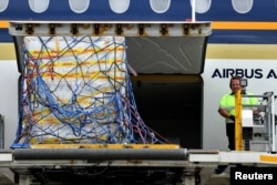Gelombang pertama pengiriman vaksin COVID-19 produksi Pfizer untuk Australia, diturunkan dari pesawat Singapore Airlines di Bandara Internasional Sydney, Australia, 15 Februari 2021.