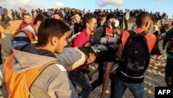 Palestinians carry away a protester during a demonstration calling for an end to the Israeli blockade on Gaza, on a beach in Beit Lahia near the maritime border with Israel, Nov. 5, 2018.