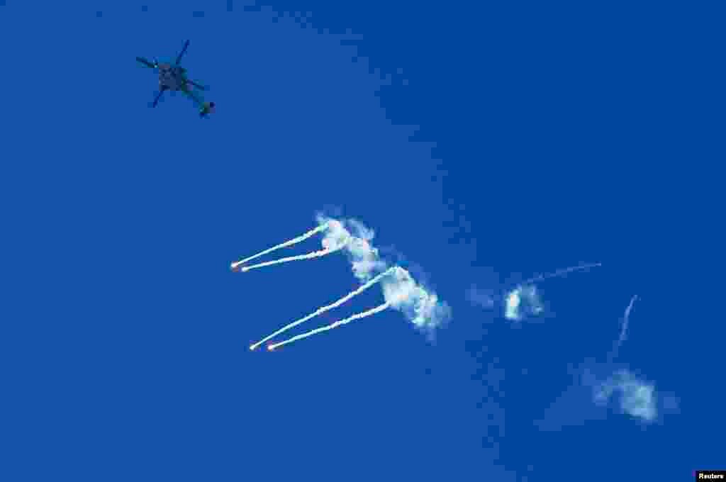 An Israeli Apache helicopter fires flares over the Israeli-Gaza border as seen from the southern town of Sderot, Israel, July 11, 2014. 