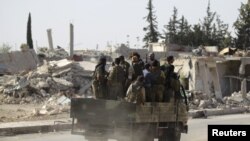 Des rebelles passent des bâtiments en ruine à al-Rai town, au nord d'Alep, Syrie, le 2 octobre 2016. 