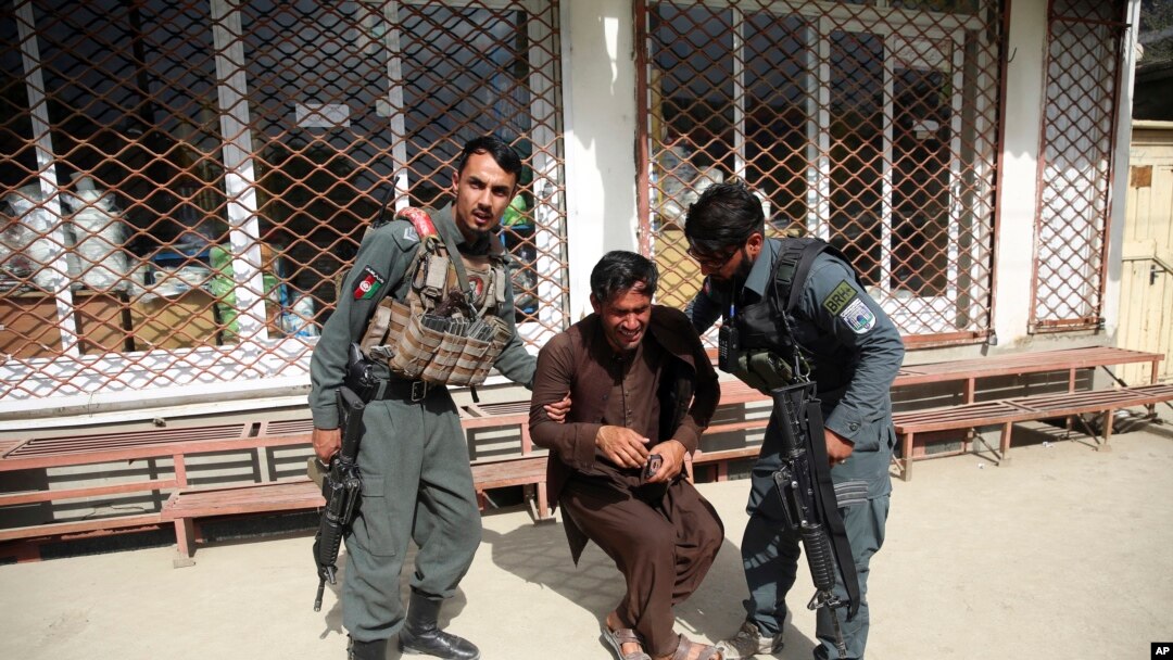 Seorang polisi menenangkan seorang pria setelah serangan terhadap sebuah rumah sakit bersalin di Kabul, Afghanistan, 12 Mei 2020. (Foto: AP)