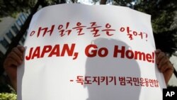 A protester holds a sign during an anti-Japan rally denouncing Japan's sovereignty claim on the Dokdo islets, or Takeshima in Japanese, in front of the Japanese embassy in Seoul, July 21, 2011