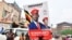 A supporter of Ugandan opposition Presidential candidate Robert Kyagulanyi also known as Bobi Wine, carry his electoral campaign poster ahead of the presidential and parliamentary elections, in Kampala, Uganda, Jan. 12, 2021.