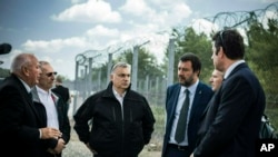 El premier húngaro Viktor Orban, centro, el ministro del Interior de Italia Matteo Salvini, 3ro desde la der., y el ministro del Interior de Hungría Sandor Pinter, 2do desde la izq. durante una visita a la frontera húngara-serbia a 180 kms al sureste de Budapest. 2 mayo 2019.