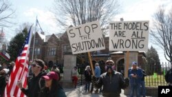 FILE - Protesters gather outside Minnesota Gov. Tim Walz's official residence in St. Paul, Minn., April 17, 2020, to call on him to loosen stay-at-home restrictions.