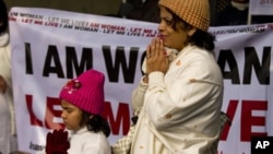 An Indian woman and her daughter pray as they take part in a silent protest to mourn the death of a gang rape victim in New Delhi, India, Tuesday, Jan. 1, 2013.