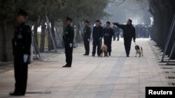 中国武警在北京街道站岗，携带警犬的保安人员在巡逻。（资料照）