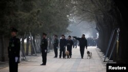 中国武警在即将召开两会的北京人大会堂附近街道上站岗，携带警犬的安保人员在巡逻。（2019年3月3日）