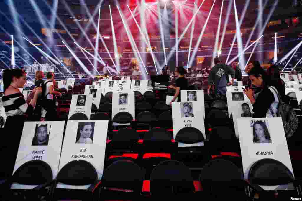 Journalists walk through cardboard cutouts showing where attendees will sit for the upcoming 2016 MTV VMA awards in New York.