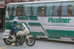 Sebuah bus yang diyakini tengah mengangkut migran Myanmar, terlihat bergerak menuju pangkalan Angkatan Laut di Lumut, di luar Kuala Lumpur, Malaysia, 23 Februari 2021. (Foto: Mohd RASFAN / AFP)