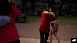 A couple dances tango at a park amid the COVID-19 pandemic in Buenos Aires, Argentina, Sunday, June 6, 2021. (AP Photo/Natacha Pisarenko)