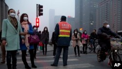 Pedestrians wearing masks wait in heavy pollution to cross traffic in Beijing, China, March 2015. (AP) 