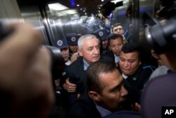FILE - Otto Perez Molina is escorted by police to court to face corruption charges, following his resignation in Guatemala City, Sept. 3, 2015.