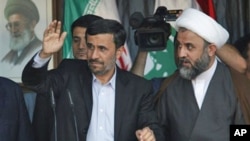 Iranian President Mahmoud Ahmadinejad, left, gestures to the crowds, with Hezbollah's commander in south Lebanon, Sheik Nabil Kaouk, right, during a rally organized by Hezbollah in the southern border town of Bint Jbeil, 14 Oct 2010