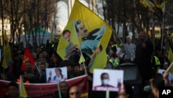 FILE - Pro-Kurdish people wave flags with the face of jailed Kurdistan Workers' Party, or PKK, leader Abdullah Ocalan during a protest demanding his freedom in Brussels, Feb. 27, 2019. 