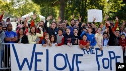 Kerumunan warga bersorak menanti Paus Fransiskus yang berkeliling dalam parade di Washington DC.