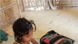Grade 1 Learner Using Workbook at home in Rohingya Refugee Camp, Cox's Bazar, Bangladesh