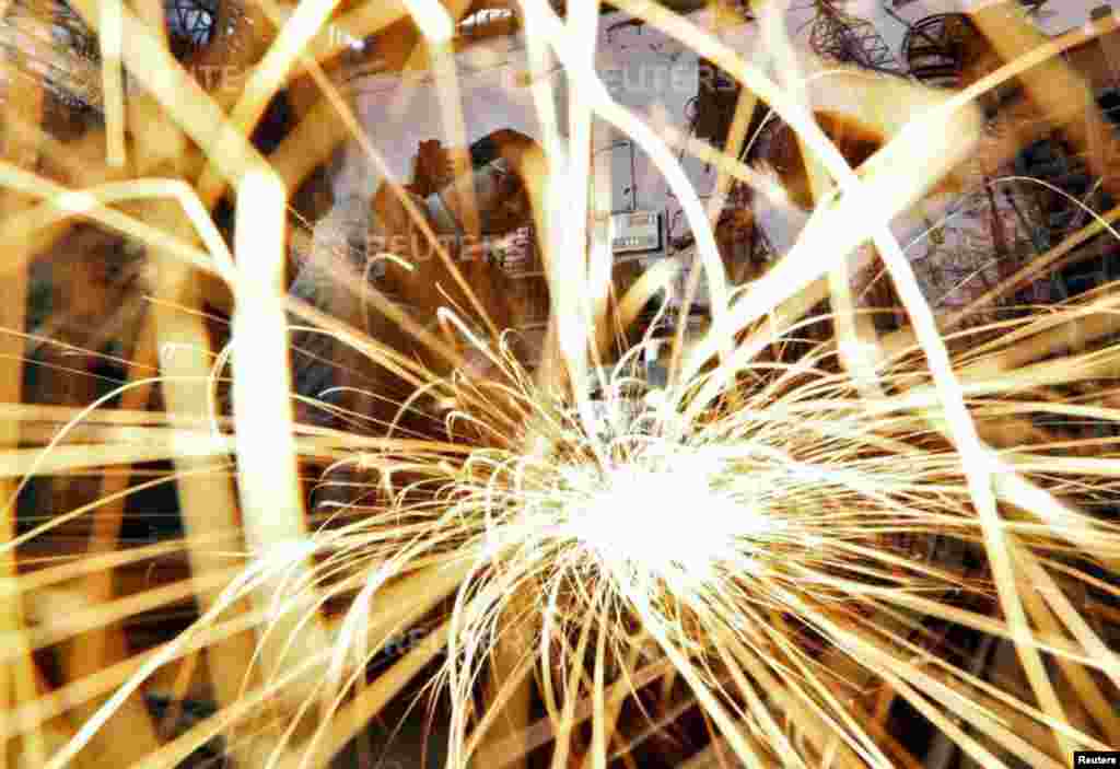 A worker grinds an iron window frame used in a dairy machine at a manufacturing unit in Ahmedabad, India. 