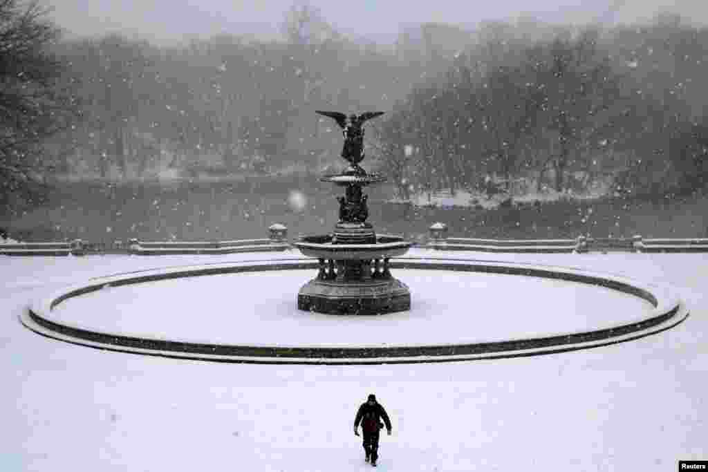 A man walks in Central Park as snow falls in Manhattan, New York, March 14, 2017.