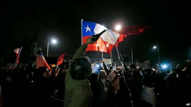 Una multitud se reunió frente al Hospital Militar de Santiago ondeando banderas chilneas celebrando la muerte del general Manuel Contreras, el sábado, 8 de agosto de 2015.