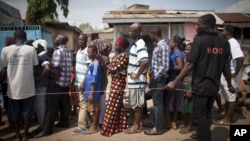 People wait in line to vote during an unexpected second day of balloting at a polling station near Accra, Ghana, Dec. 8, 2012.