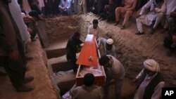 Um corpo a ser transportado depois do ataque do Estado Islâmico num casamento em Cabul, Afeganistão 
