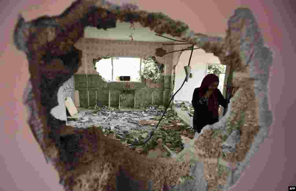 A woman checks the remains of the house of a Palestinian man, who killed three Jewish residents of a nearby Israeli settlement, after it was demolished by Israeli authorities in the village of Kobar, near Ramallah, in the occupied West Bank.