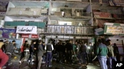 People gather in front of the mall in Baghdad, Iraq, on Jan. 11, 2016. Gunmen stormed into the mall Monday, spraying bullets at shoppers before blowing themselves up.