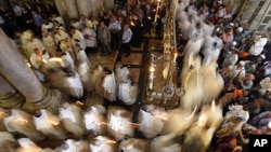 Members of the Catholic clergy hold candles as they take part in a procession at the end of Easter Mass in the Church of the Holy Sepulchre in Jerusalem's Old City April 8, 2012.