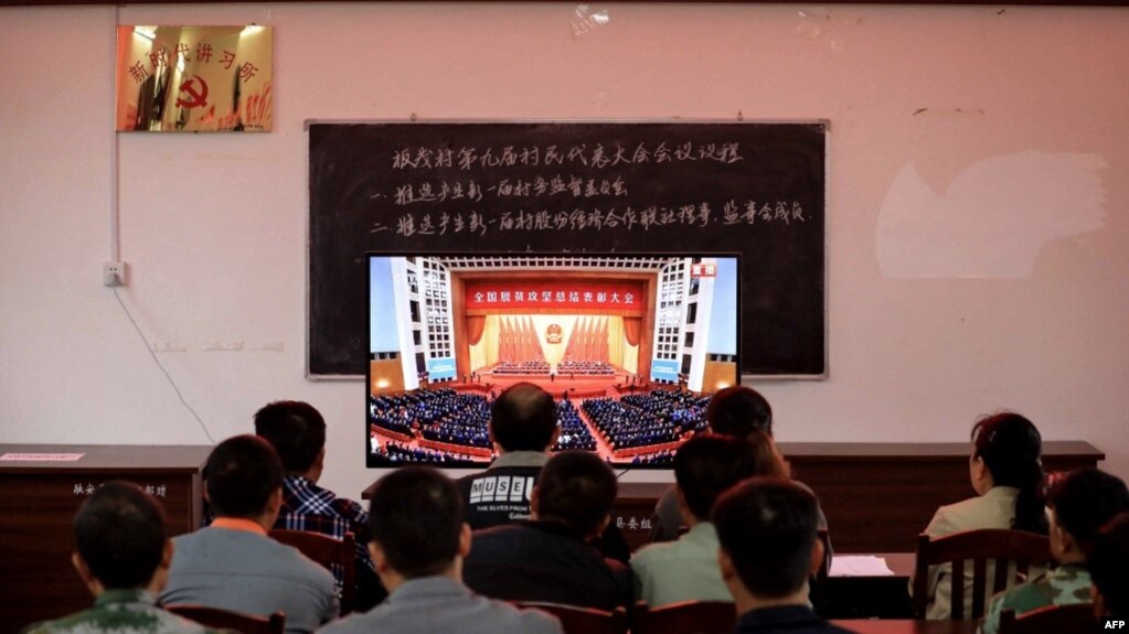 广西柳州一个村庄的村民正在观看在北京人大会堂举行的全国脱贫攻坚总结表彰大会的电视直播。（2021年2月25日）(photo:VOA)