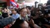 FILE - Sam Rainsy, center, leader of the opposition Cambodia National Rescue Party (CNRP), talks to journalists upon his arrival at Phnom Penh International Airport in Phnom Penh, Cambodia, Aug. 16, 2015.