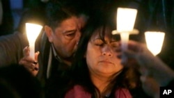 Beatrez Gonzalez, right, mother of California State Long Beach student Nohemi Gonzalez holds up candle with Nohemi's step-father Jose Hernandez, left, during a memorial service on Sunday, Nov. 15, 2015.