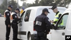 French policemen check identity papers and cars in La Turbie, southeastern France, near the Franco-Italian border, in spite of the EU's passport-free zone Schengen, as security measures are taken ahead of the G20 Summit of Cannes, October 31, 2011.