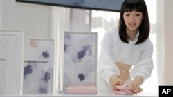 FILE - In this July 11, 2018 photo, Japanese organizational expert Marie Kondo folds an item of clothing as she introduces her new line of storage boxes in New York. (AP Photo/Seth Wenig) 