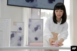 In this July 11, 2018 photo, Japanese organizational expert Marie Kondo folds an item of clothing as she introduces her new line of storage boxes