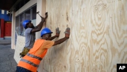Работники укрупляют окна домов от урагана «Мэтью» в городе Кингстон, Ямайка. 1 апреля 2016 г. 