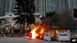 Bomberos tratan de apagar el fuego causado por manifestantes que incendiaron barricadas y destruyeron señalizaciones en Tung Chung, cerca del aeropuerto de Hong Kong, el domingo 1 de septiembre de 2019. AP/Vincent Yu.