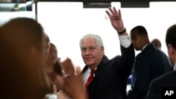 Outgoing Secretary of State Rex Tillerson waves goodbye as he walks out of the doors of the State Department in Washington, March 22, 2018, after speaking to employees upon his departure. 