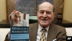 Dr. Henry Heimlich holds his memoirs prior to being interviewed at his home in Cincinnati, Feb. 5, 2014. He died Dec. 17, 2016, at a hospital in Cincinnati after suffering a heart attack days earlier. He was 96.