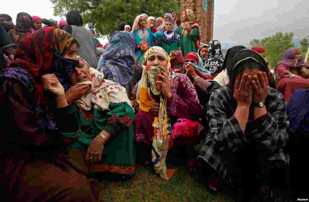Relatives mourn as they watch the body of Umar Kumhar, a civilian who according to local media was killed during clashes with Indian security forces near the site of a gun battle, during his funeral at Pinjora village in Kashmir's Shopian district.
