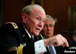 Chairman of the Joint Chiefs Gen. Martin Dempsey speaks next to U.S. Secretary of Defense Chuck Hagel during the defense subcommittee of the Senate Appropriations Committee on Capitol Hill in Washington, June 18, 2014.