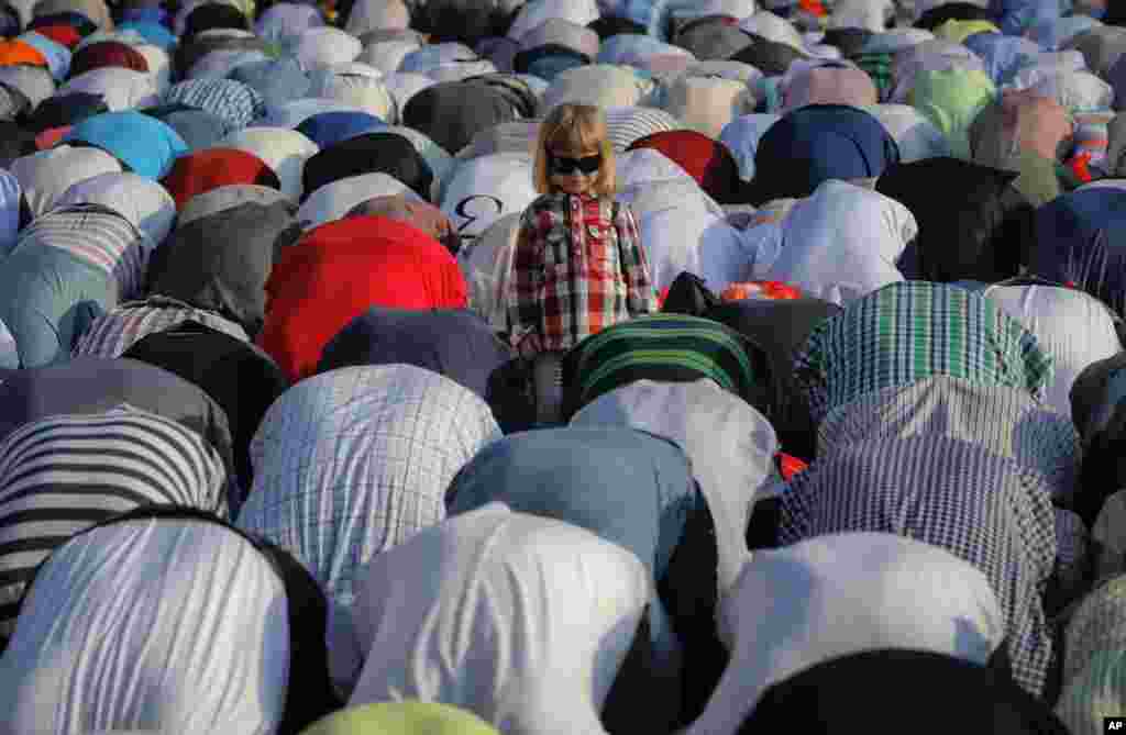 A child stands among Muslims taking part in Eid al-Fitr prayers in Bucharest, Romania.