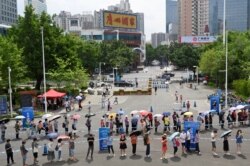 چین کے شہر گوانگ ژو میں ایک ویکسین سینٹر کے باہر لوگ اپنی باری کا انتظار کر رہے ہیں۔ 29 مئی 2021