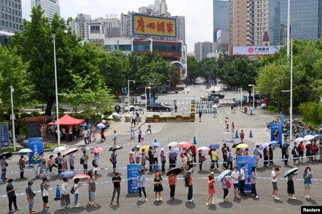 چین کے شہر گوانگ ژو میں ویکیسن لگانے کے ایک مرکز کے باہر لمبی قطار میں لوگ اپنی باری کا انتظار کر رہے ہیں۔