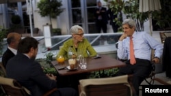 El secretario de Estado de EE.UU., John Kerry, consulta con miembros de la delegación estadounidense en la terraza del hotel donde se realizan las conversaciones nucleates con Irán el jueves, 2 de julio de 2015.
