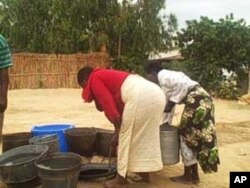 Women collect water from unprotected well