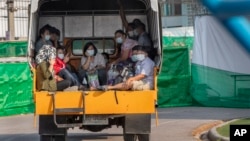 Migrant workers and their families ride in the back of a truck as they wait to be admitted to a field hospital for COVID-19 patents, Monday, Jan. 4, 2021, in Samut Sakhon, South of Bangkok, Thailand. (AP Photo/Gemunu Amarasinghe) 