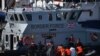 Petugas perbatasan Inggris memindahkan para migran ke kapal perbatasan di Marina, Dover, Inggris, pada 13 Agustus 2020. Para migran itu sebelumnya ditangkap ketika melakukan perjalanan dari Prancis menuju Inggris. (Foto: AFP/Ben Stansall)