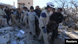 People and Civil Defense members carry a dead body removed from a destroyed Medecins Sans Frontieres (MSF) supported hospital hit by missiles in Marat Numan, Idlib province, Syria, Feb. 16, 2016. 