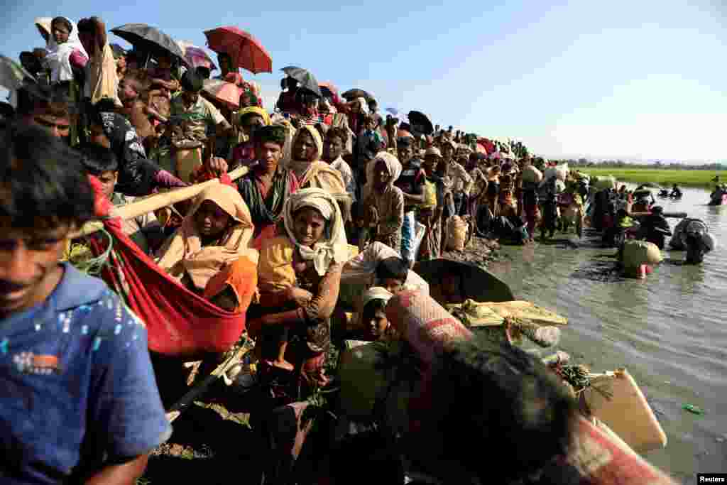 Myanmar'dan kaçan Arakanlı Müslümanlar Bangladeşli sınır muhafızları tarafından ülkeye alınıyor.